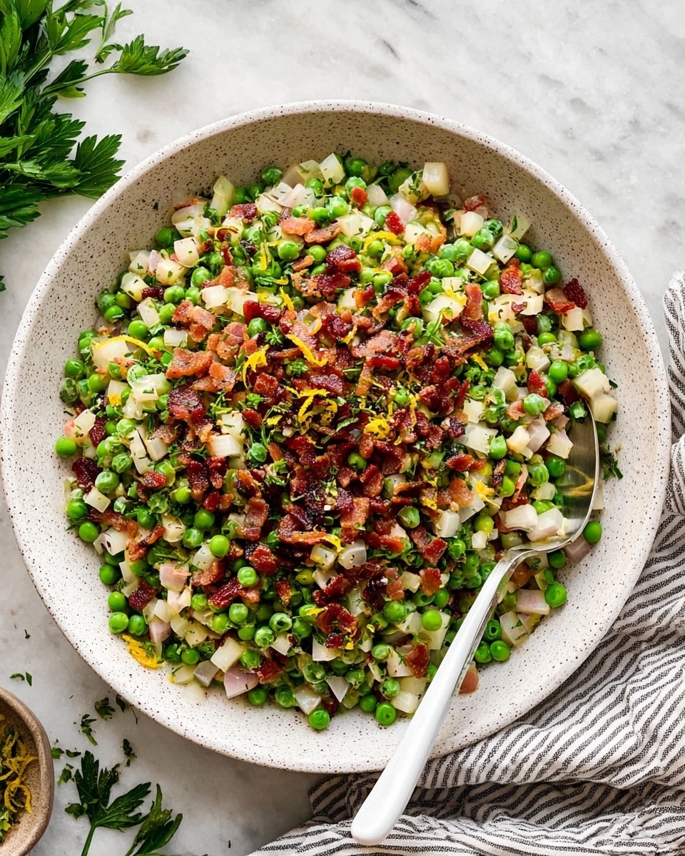 A white round speckled bowl filled with a colorful layered dish starting with a base of green peas mixed with small pale cubes of white vegetable, thin slices of light beige onions, and small pieces of green herbs. On top is a middle layer of finely chopped cooked bacon pieces in shades of dark brown and red, scattered with some yellow zest. A silver spoon with a white handle rests inside the bowl, partly submerged in the food. The bowl is placed on a white marbled surface with some parsley leaves and a striped cloth napkin nearby. Photo taken with an iphone --ar 4:5 --v 7