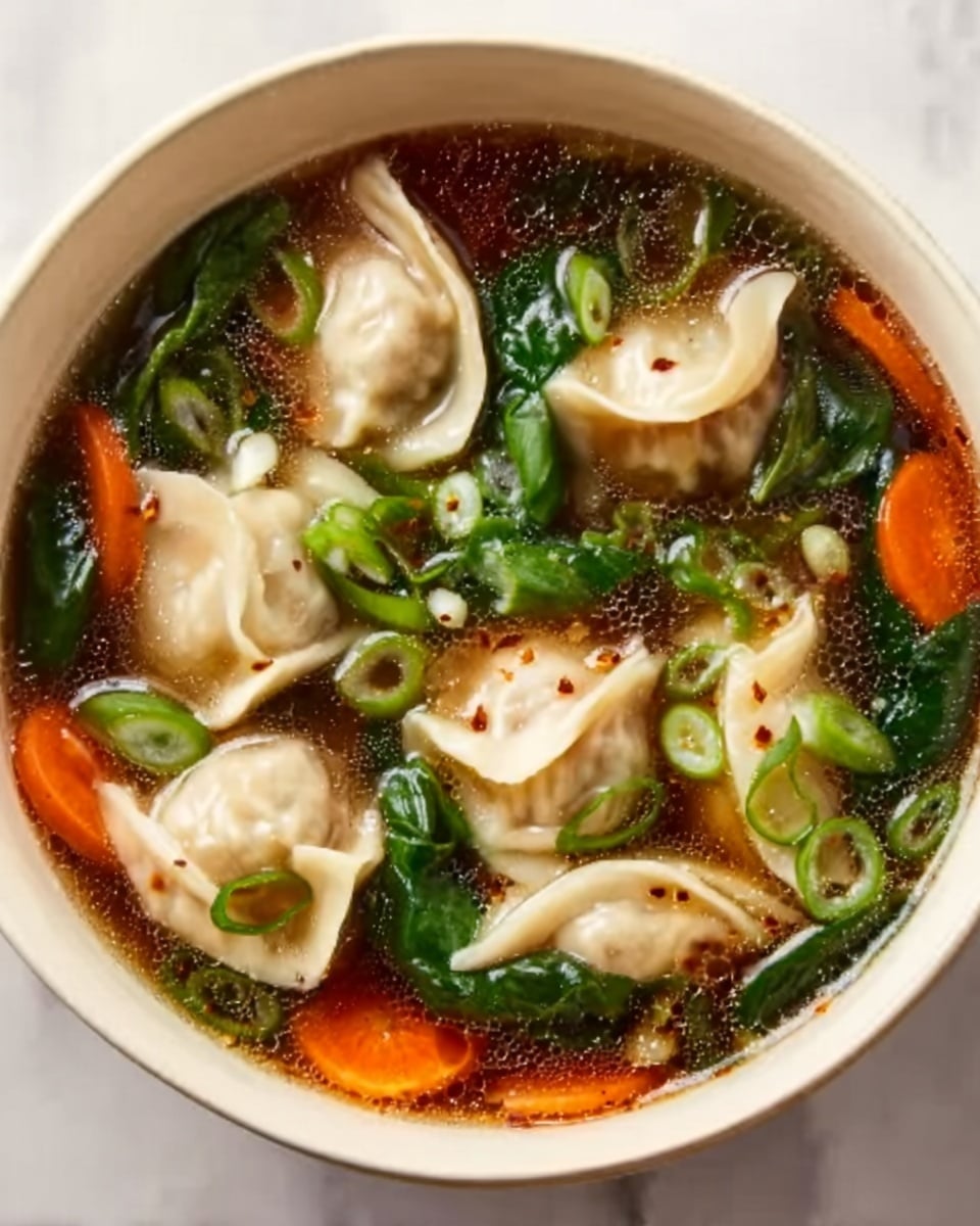 The image shows a white bowl filled with a clear soup containing several small, round dumplings that have a slightly wrinkled, soft texture. The dumplings are light beige in color and float among thin slices of bright orange carrots, dark green spinach leaves, and thinly sliced rings of fresh green onions. The broth is transparent with a gentle sheen, revealing the detailed textures of the ingredients. The bowl sits on a white marbled surface, creating a clean and bright setting. Photo taken with an iphone --ar 4:5 --v 7