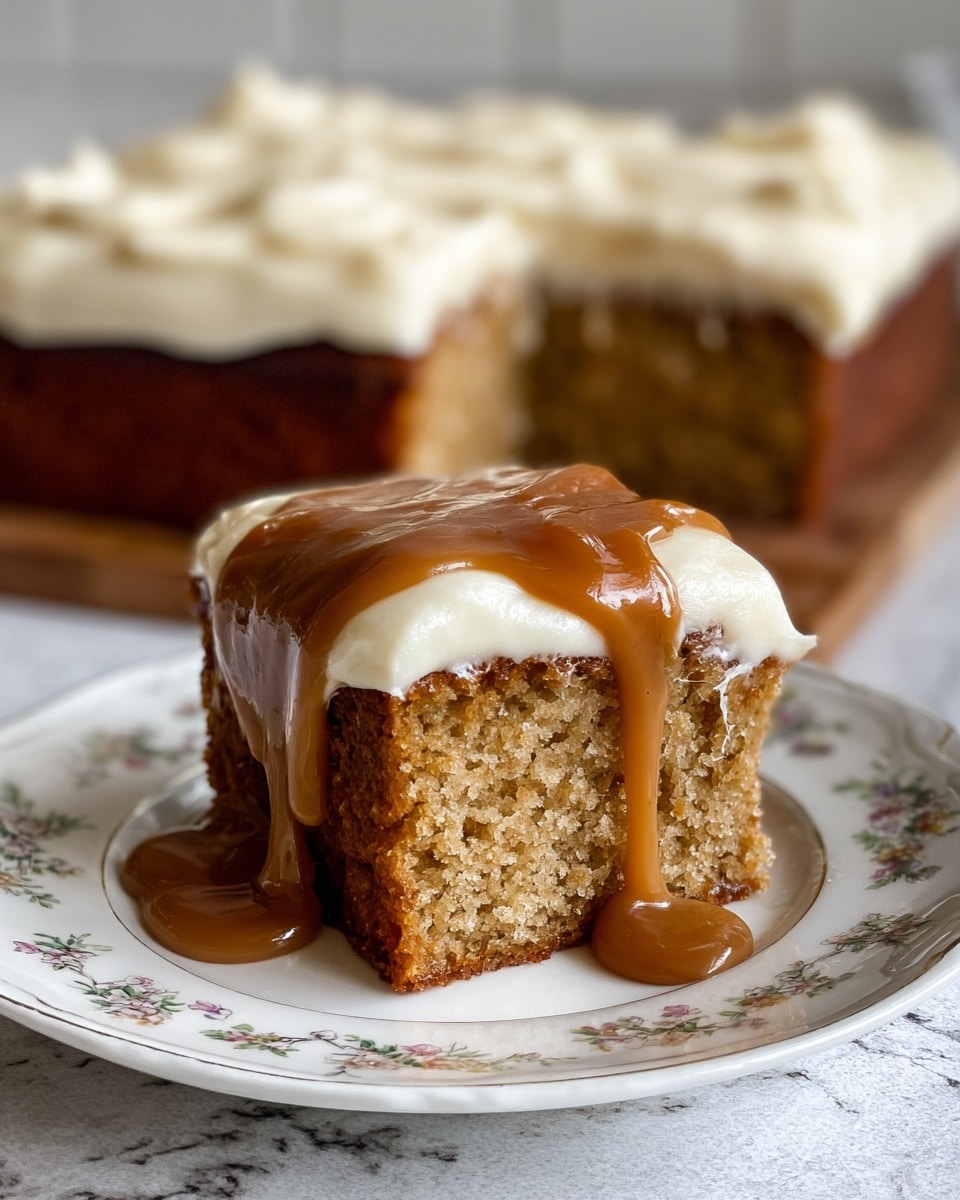 A close-up of a square slice of light brown cake with a slightly crumbly texture sits on a white plate with a delicate embossed pattern. The cake has three visible layers: the bottom thick cake layer is a light brown with small nut pieces, the middle creamy white frosting layer is smooth, and the top layer is a thick golden caramel sauce dripping down the side. In the background, a larger cake of the same kind with the same frosting but without caramel is slightly blurred, resting on a white marbled surface. Photo taken with an iphone --ar 4:5 --v 7